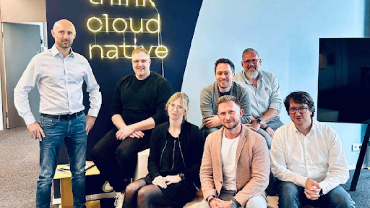 PCG Experts as a group in front of a cloud native neon sign