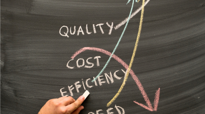 
A person's hand with a piece of chalk writing on a blackboard, illustrating two crossing trend lines: a light blue and yellow line pointing sharply up with the word "QUALITY", and a pink line with a downward-pointing arrow crossing it, featuring the words "COST" and "EFFICIENCY". The word "SPEED" is partially visible at the bottom.