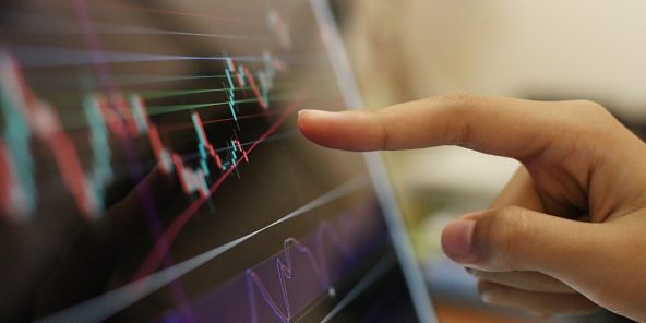 Stock charts on a tablet, symbolizing the cloud journey by Public Cloud Group PCG
