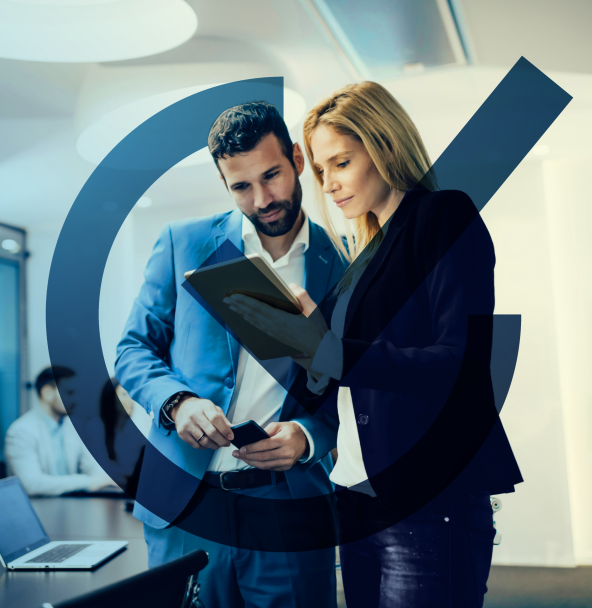 Two business experts are analyzing data on a tablet; a large, transparent checkmark icon in the foreground signifies successful verification and optimization.